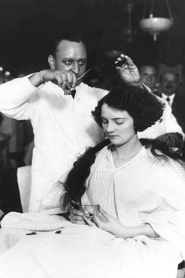 Молодая леди стрижется в мужской парикмахерской 1920
