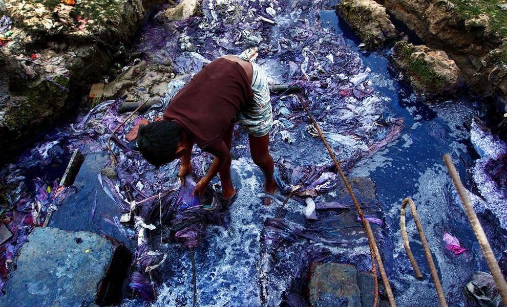 Девятилетний Джашим вылавливает части одежды в отходах с красильной фабрики в Бангладеше 2011