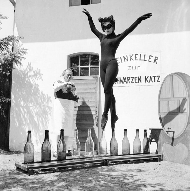 17летняя Бьянка Пассарге из Гамбурга в костюме кошки танцует на винных бутылках 1958. © Carlo PolitoBIPsHulton...