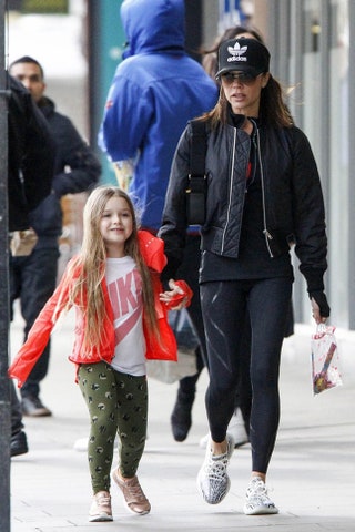 Виктория Бекхэм в кроссовках Yeezy и в кепке adidas Originals с дочерью Харпер в футболке Nike в Лондоне 2017.