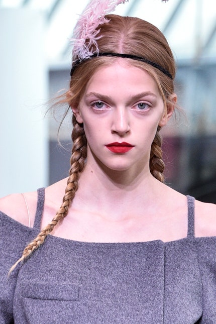 Прически с показа Prada resort 2018 две гладкие косы украшенные пером | Vogue