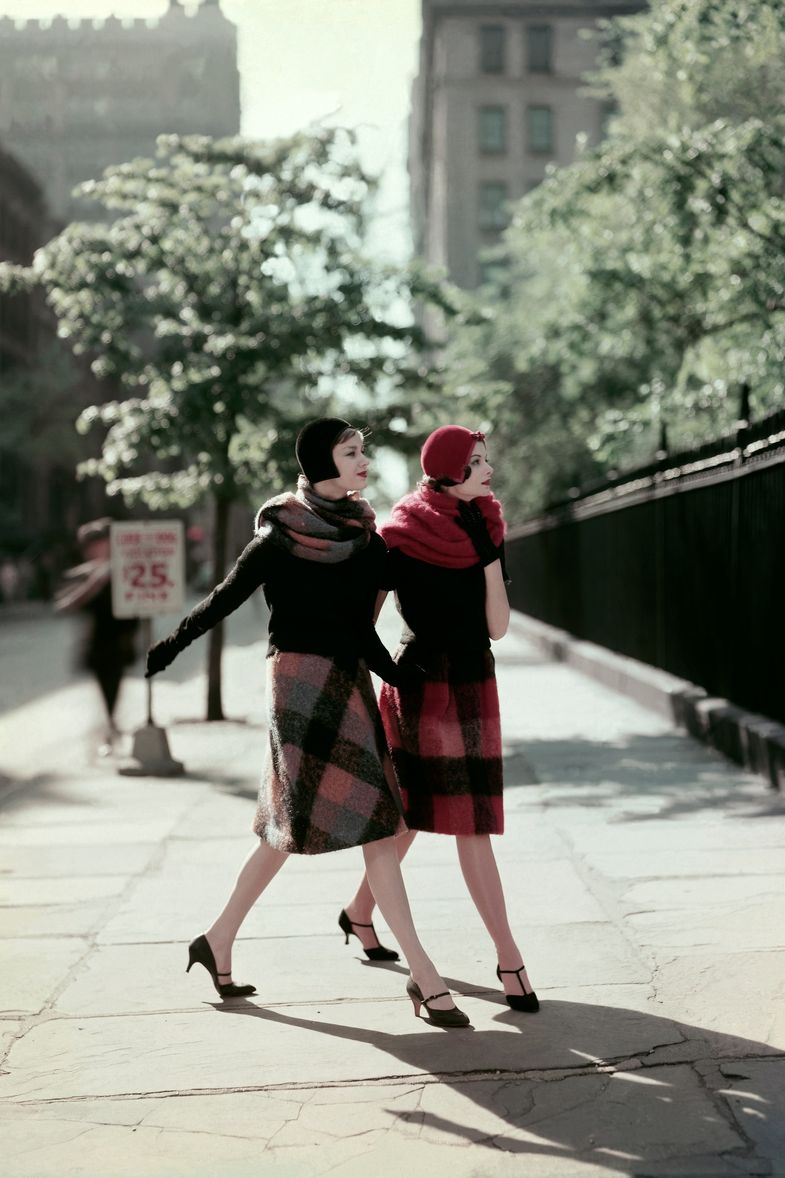 Two models walking wearing plaid skirts of mohair and nylon  one in shades of blue rust and black the second in shades...