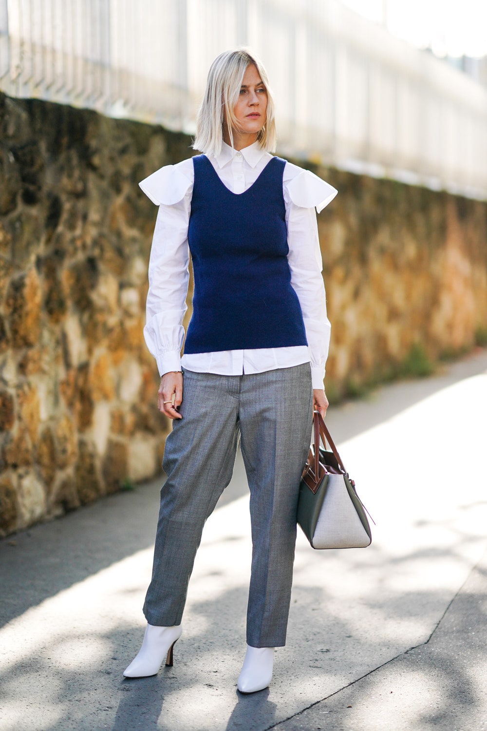 PARIS FRANCE  SEPTEMBER 27 Linda Tol wears a white ruffled shirt with shoulder pads a blue sleeveless pullover gray...
