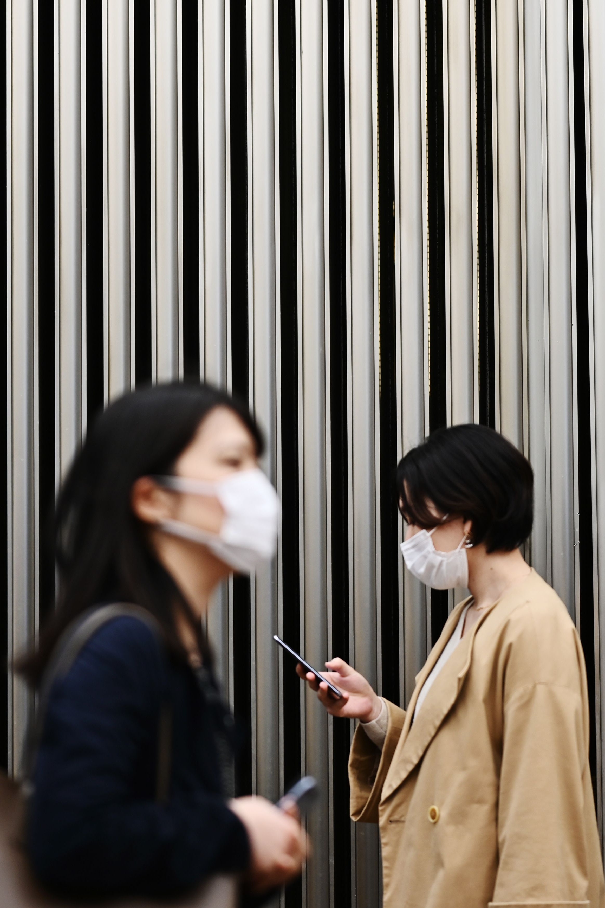 TOPSHOT  People wearing face masks amid concerns of the COVID19 coronavirus walk on a street in Tokyo's Yurakucho area...
