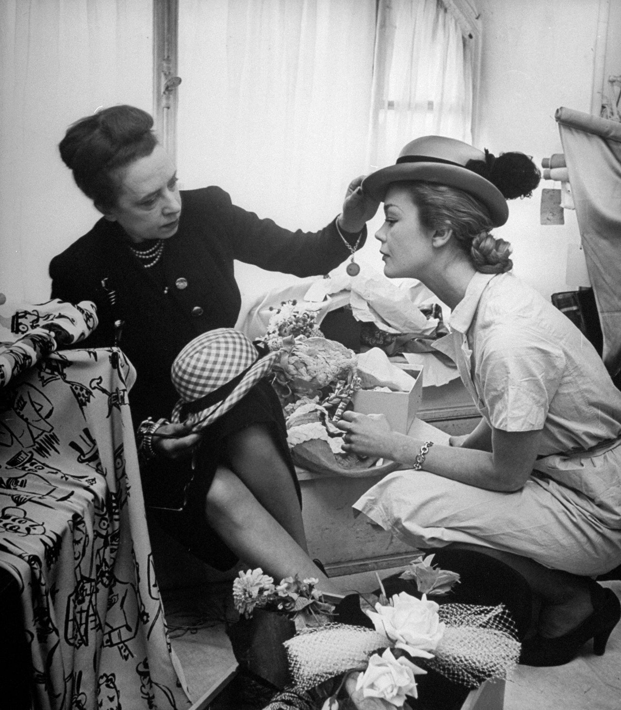 Эльза Скиапарелли примеряет шляпку на модели 1951