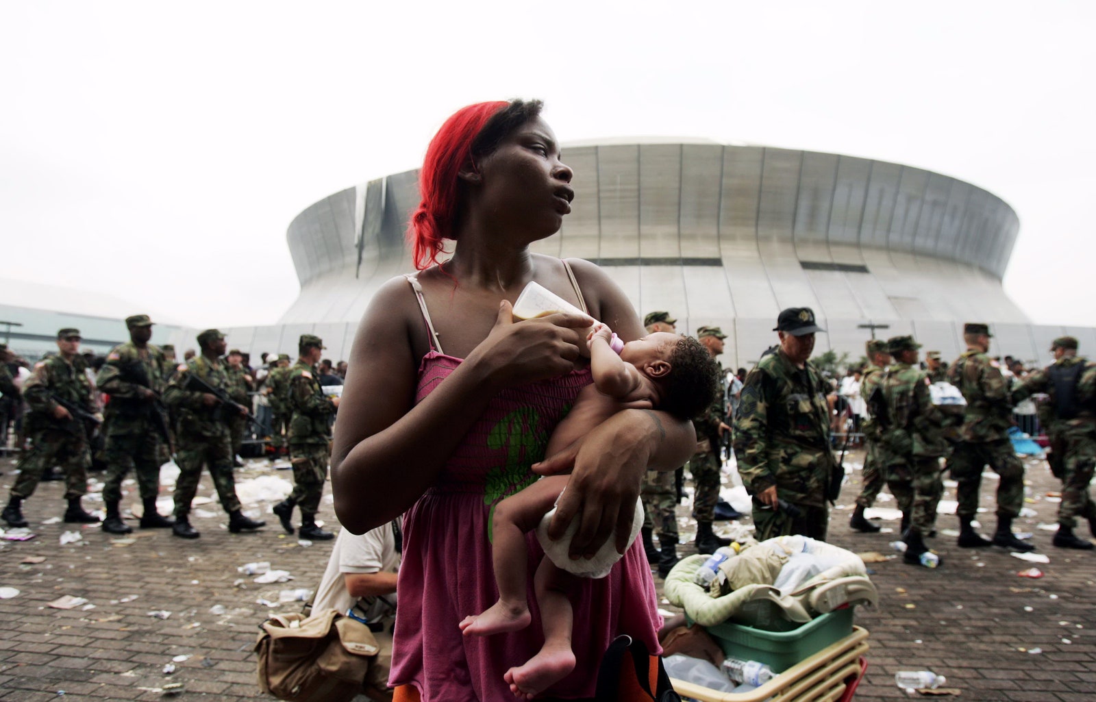 Мать кормит ребенка во время эвакуации после урагана «Катрина» в Новом Орлеане сентябрь 2005го
