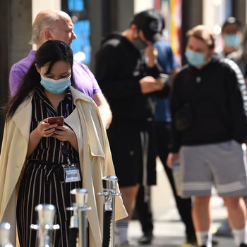 Customers some wearing face masks or coverings as a precaution against COVID19 queue outside Selfridges department store...