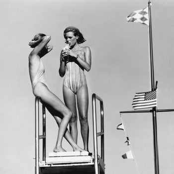 UNSPECIFIED  JUNE 1  Two models Patti Hansen on the right standing on a divingboard next to a mast with an American flag...