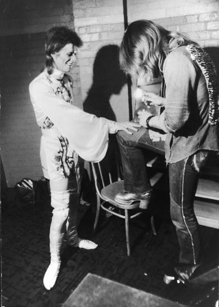 Makeup artist Pierre La Roche prepares English singer David Bowie for a performance as Aladdin Sane 1973.