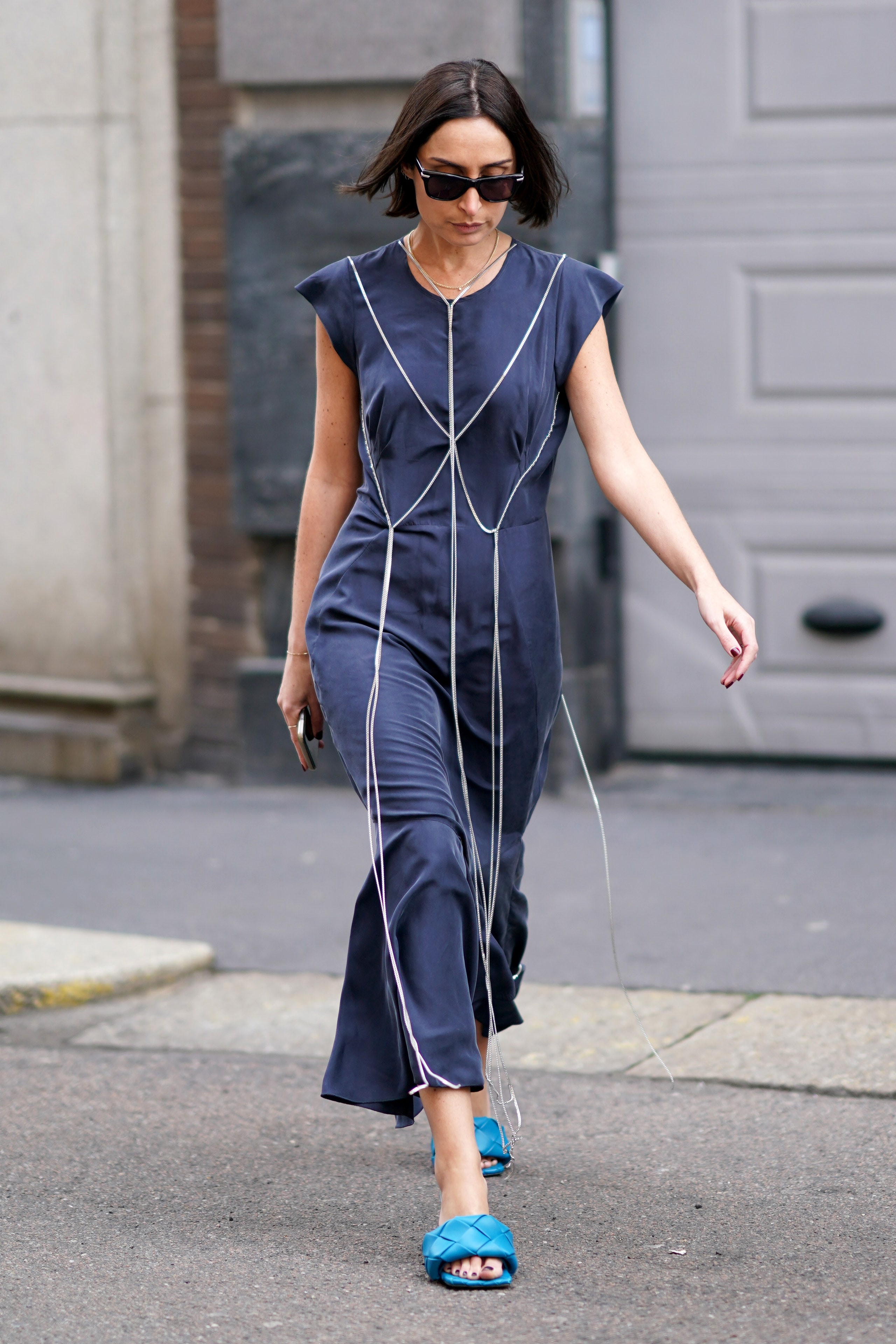 MILAN ITALY  FEBRUARY 21 Geraldine Boublil wears sunglasses a blue flowing ruffled jumpsuit with flare pants blue...