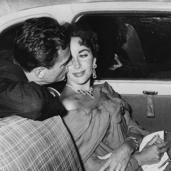 Elizabeth Taylor and her husband Mike Todd  sheltering from the rain in a car.