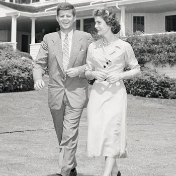 Senator John F. Kennedy and Miss Jacqueline Bouvier stroll across the lawn of his family's home after announcing their...