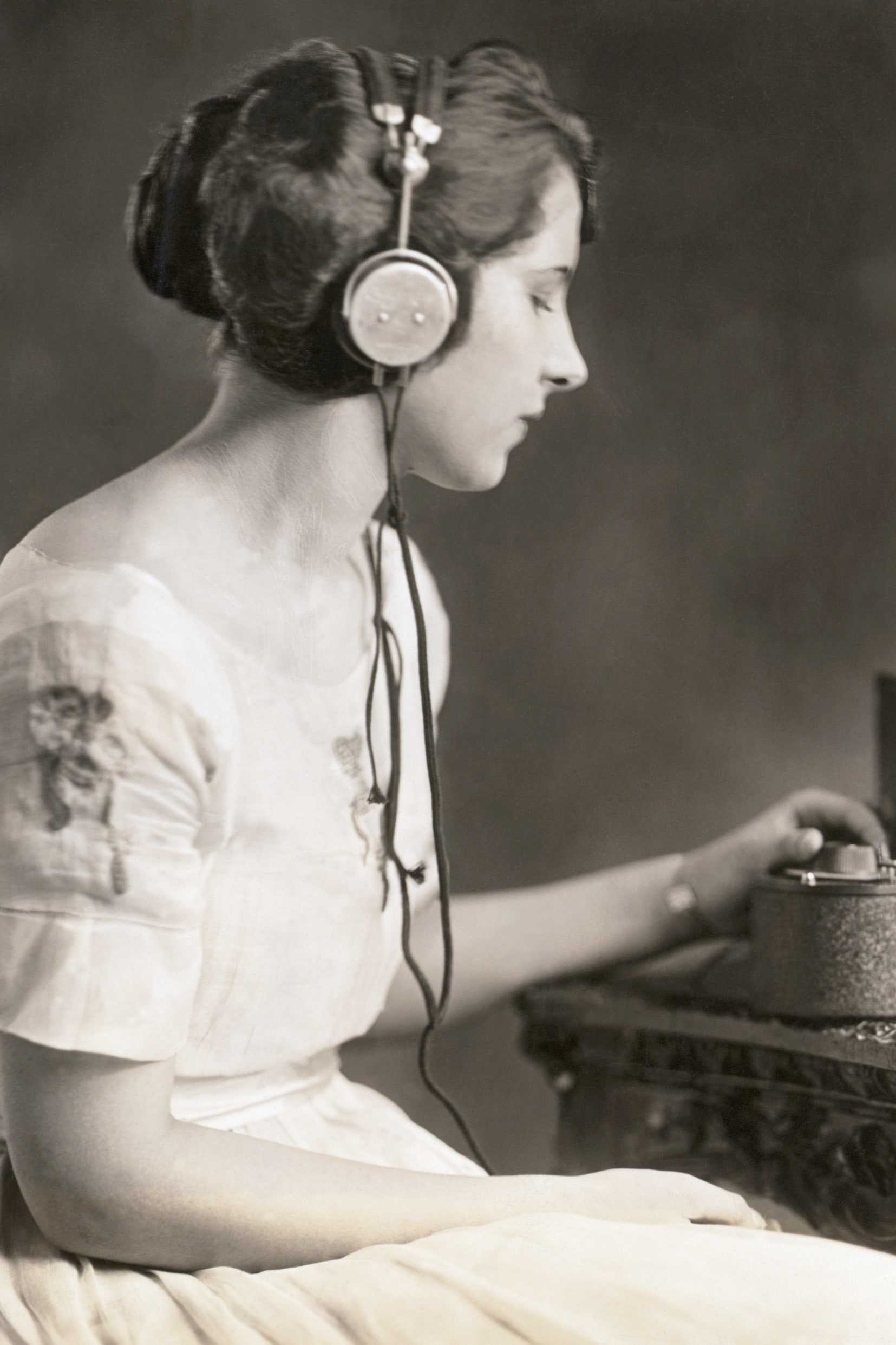Evelyn C. Lewis Miss Washington 1921 listens to the radio. She tunes in by adjusting the condenser.