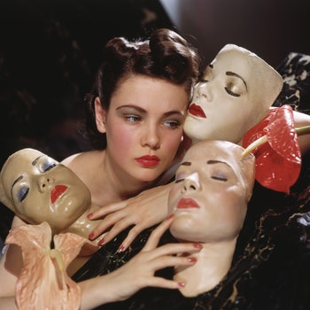 Actress Gene Tierney posed with three portrait masks made by Lillian Bettinger and two anthurium flowers.    Local...