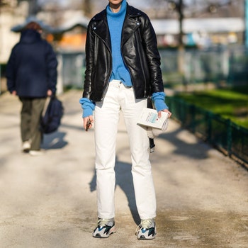 PARIS FRANCE  JANUARY 22 A model wears a blue wool pullover a black leather jacket white pants sneakers outside Elie...