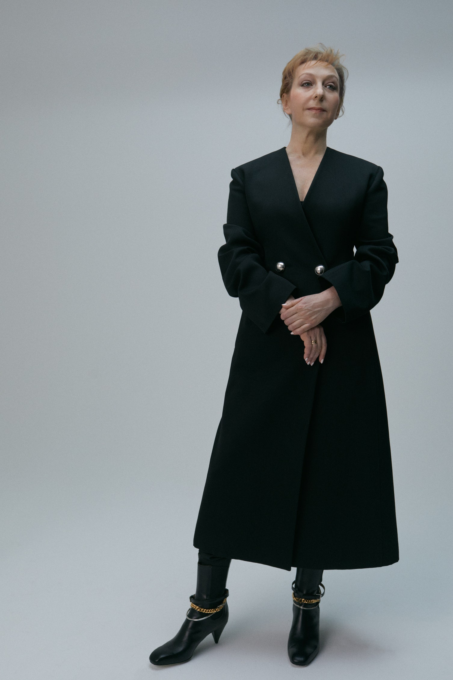 Maryana Lysenko wearing black long woollen coat and black leather boots