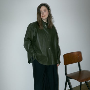 Anastasiya Spichka wearing black leather shirt black woollen trousers and black leather shoes