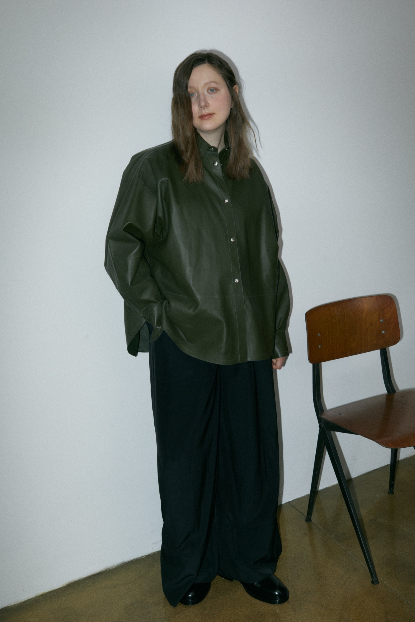 Anastasiya Spichka wearing black leather shirt black woollen trousers and black leather shoes