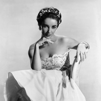 1956Actress Elizabeth Taylor is shown seated wearing a wedding gownlike dress and a pretty tiara.