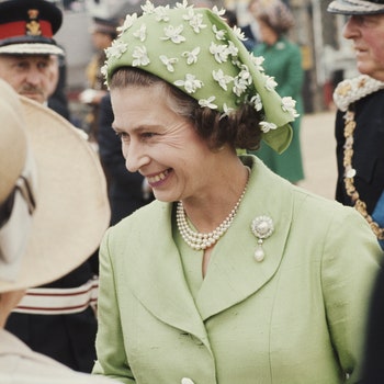 Queen Elizabeth II wearing a green jacket and beribboned hat circa 1973. The hat is by milliner Simone Mirman.