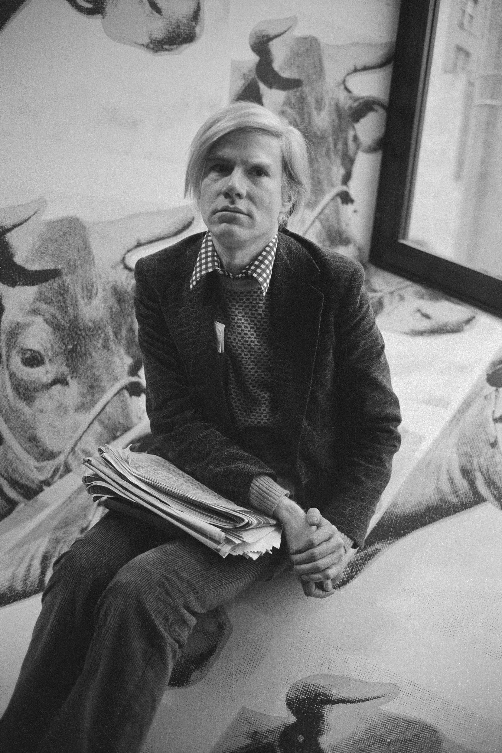 Andy Warhol sitting during the opening of his exhibition at the Whitney Museum.