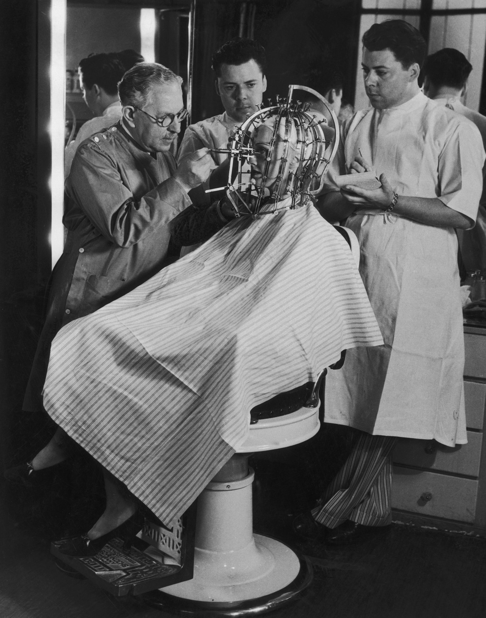 Макс Фактор проводит измерения головы и лица женщины с помощью калибратора красоты 1932