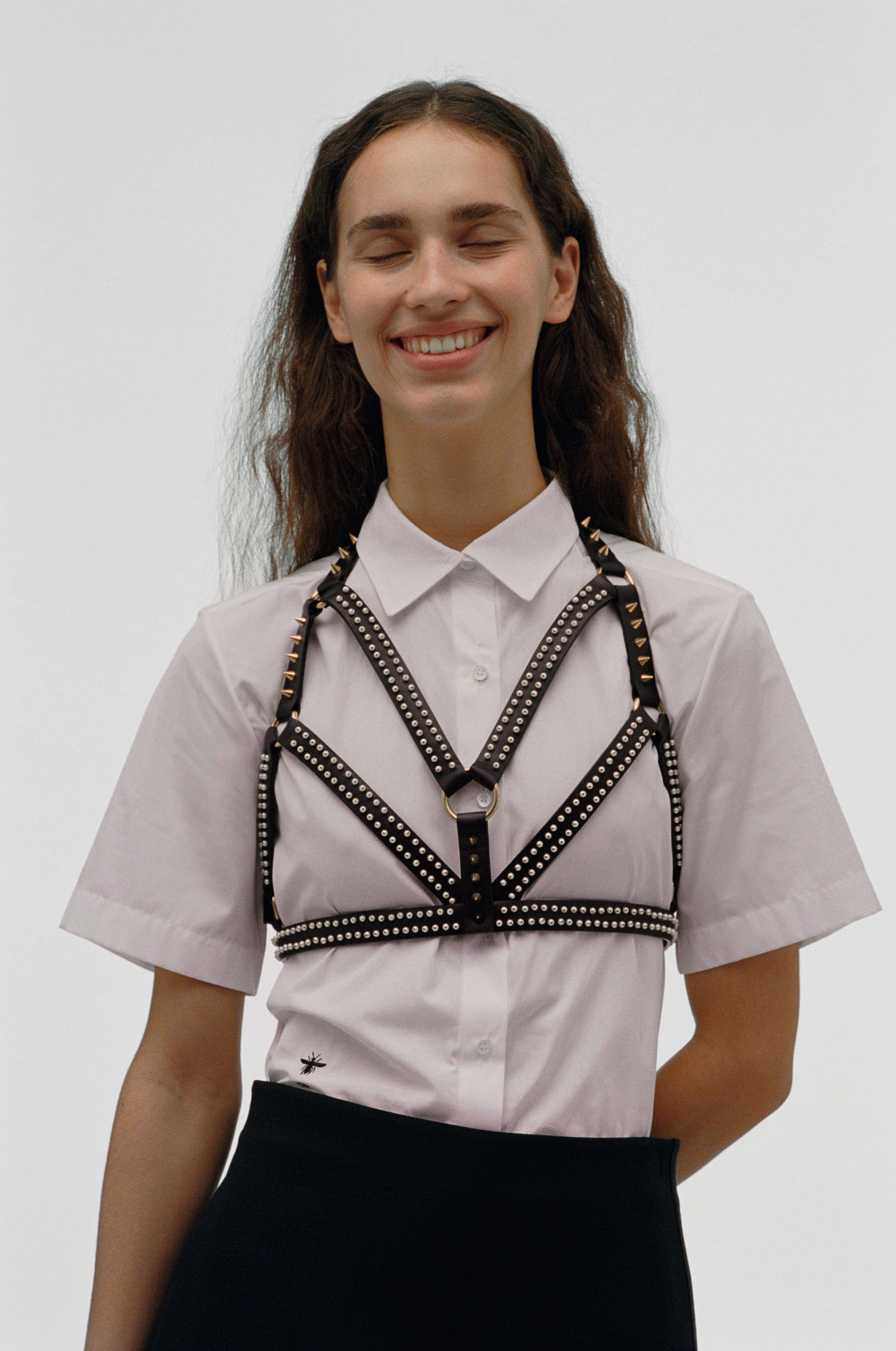 На Асе хлоп­ко­вая ру­баш­ка ко­жа­ная пор­ту­пея с бу­си­на­ми и ме­тал­ли­че­ски­ми за­клеп­ка­ми все Dior