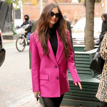 Emily Ratajkowski arrives in a pink blazer black tights and kneelength boots at her McNally Jackson book signing in New...