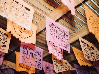 Потолок ресторана на репетиционном ужине украшали традиционные papel picado сделанные специально к празднику.