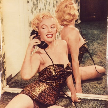 Marilyn Monroe pinup photo speaking on a telephone and reclining against a mirror 1950.